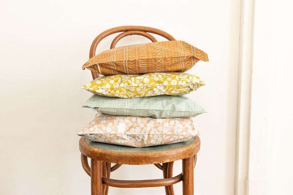 a stack of four large 10x13 inch poly mailer shipping bags packaged and ready to ship on top of a chair
