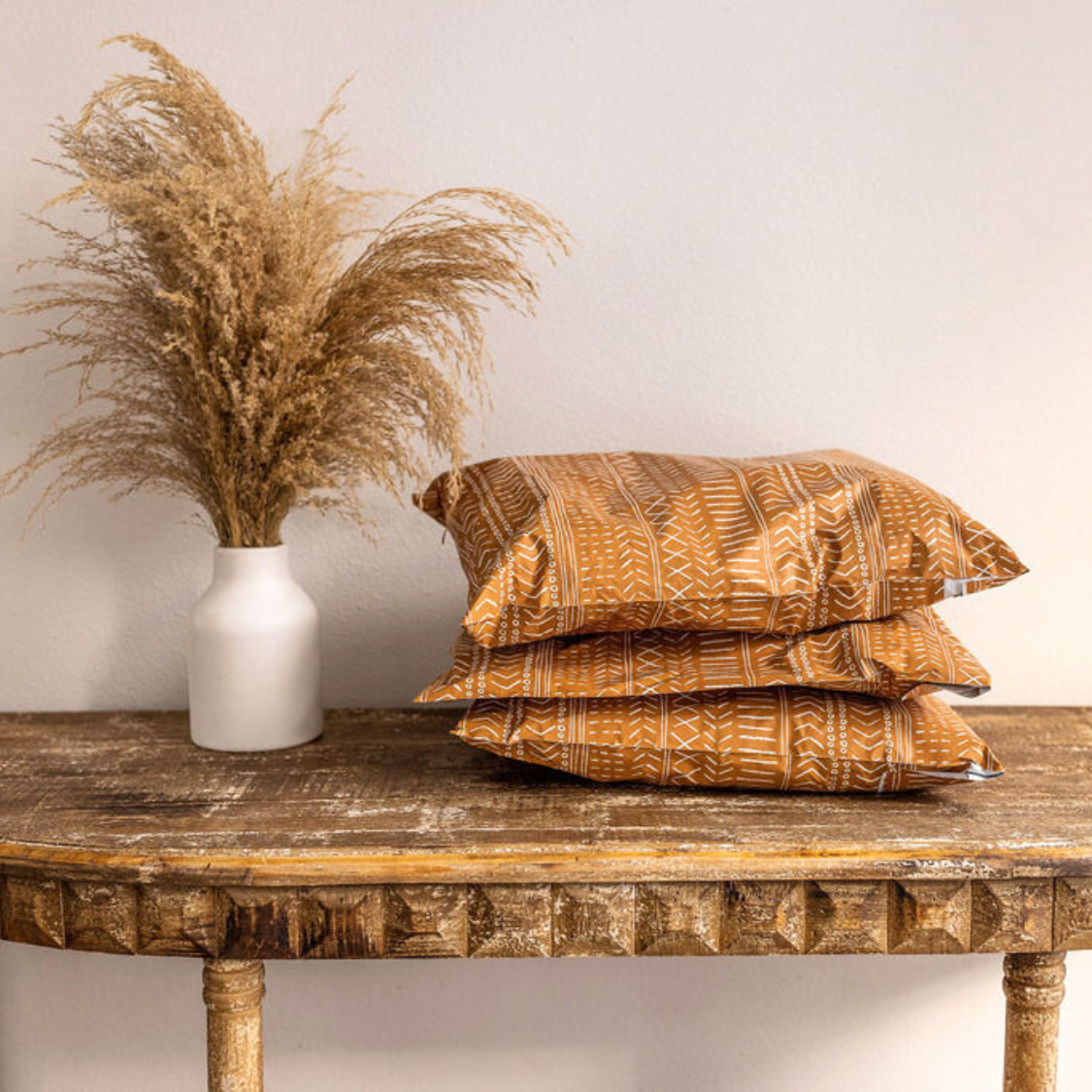 Boho Brown Poly Mailer from Favorite Supplies displayed on a table next to a plant, offering a size perspective with its compact design (10x13) and stylish aesthetic.