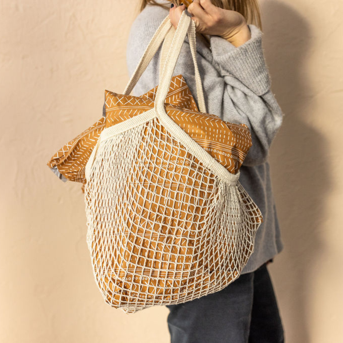 Woman carrying Favorite Supplies' Boho Brown Poly Mailers in a bag, ready to ship small business orders. Effortless and stylish shipping for a seamless customer experience.