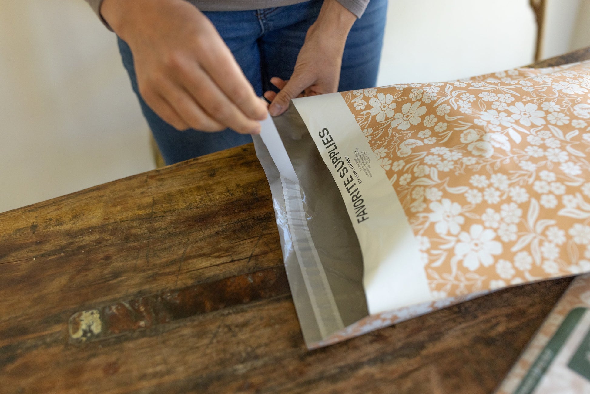 Order fulfillment, packaging orders process with a pretty dusty pink shipping mailers.